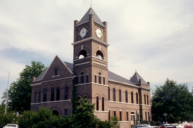 A photo of Tallahatchie County Courthouse, a red brick building with a clock tower.